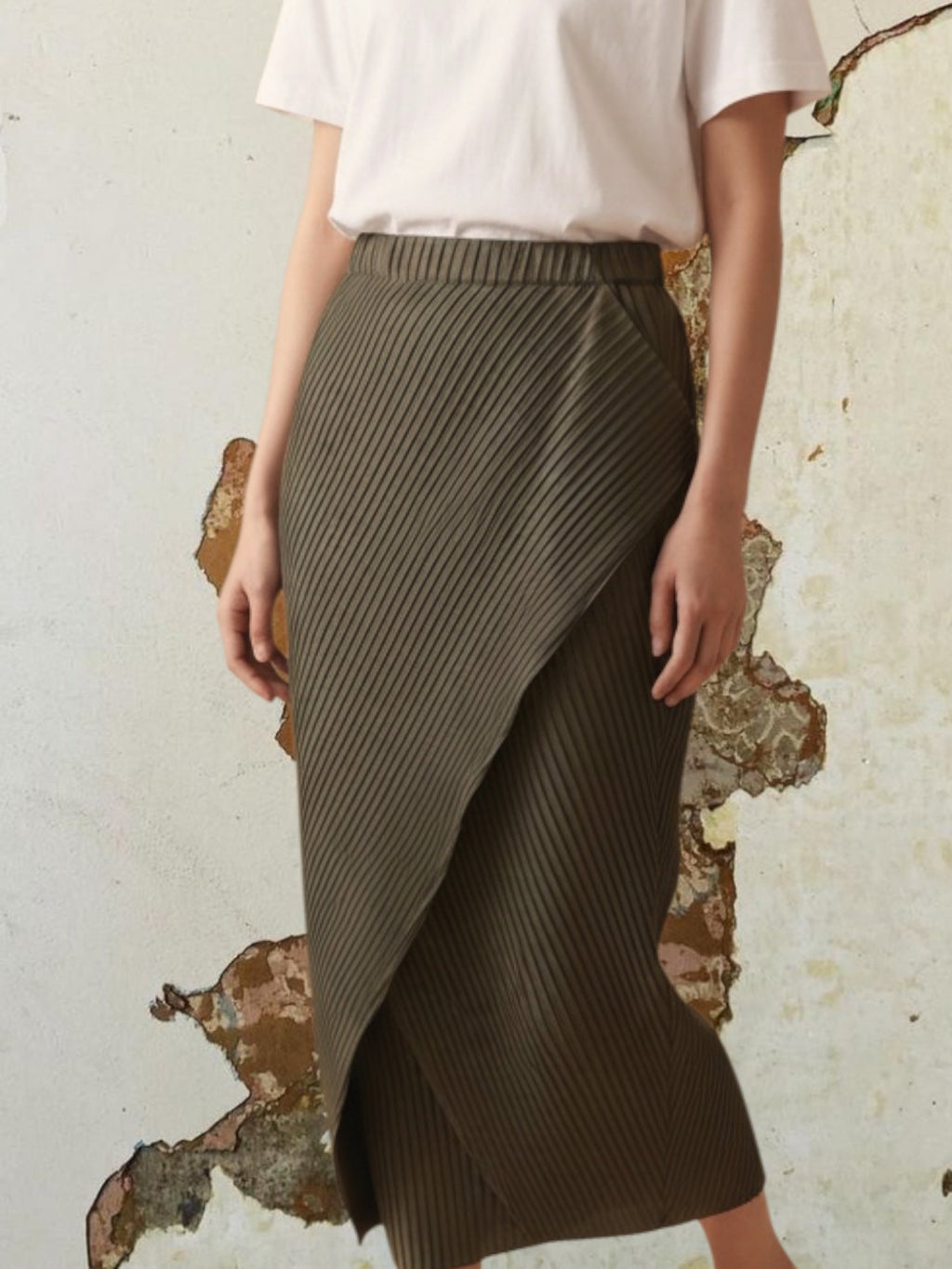 Celeni dark green pleated polyester asymmetric midi skirt with elastic waist.